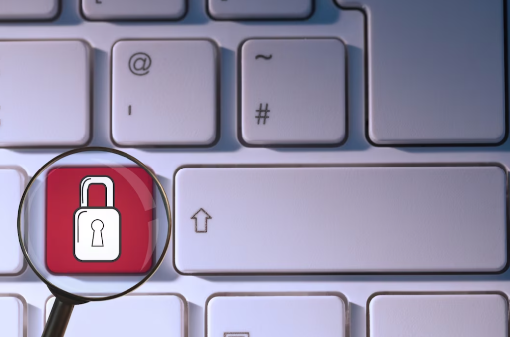 white laptop keyboard and red locks under the magnifying glass