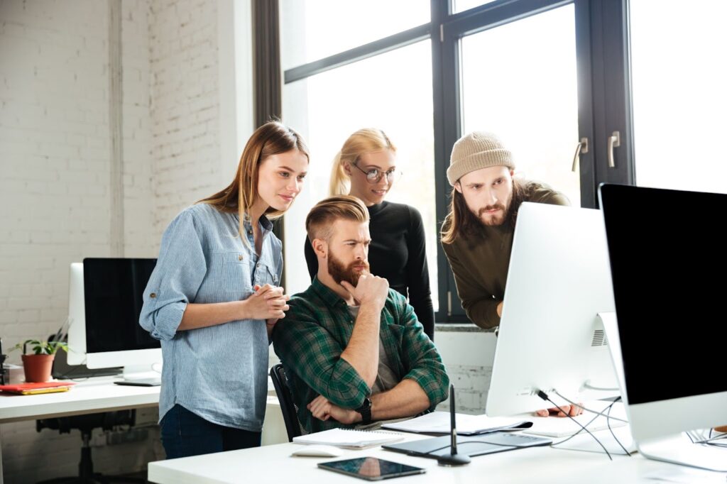 Serious colleagues in office looking on computer